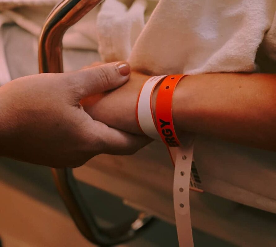 person wearing orange and white silicone band